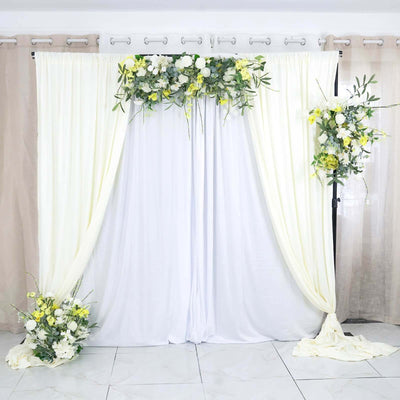 Elegant floral backdrop with drapes and arrangements for events and photoshoots.