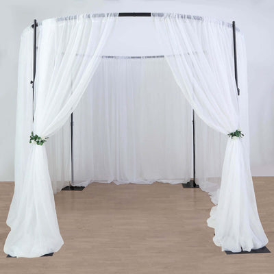 White wedding canopy with flowing drapes and greenery accents