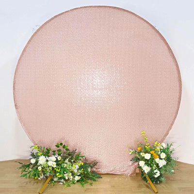 Rose gold circle backdrop with floral arrangements on either side.