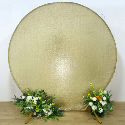 Gold round backdrop with floral arrangements on either side.