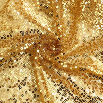 Gold and black sequin fabric in a swirling pattern.