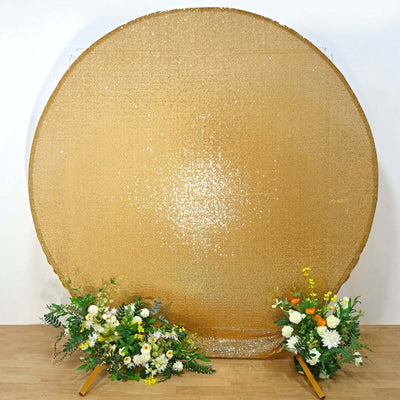 Gold sequin backdrop with floral arrangements on each side.