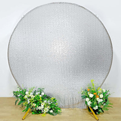 Silver reflective backdrop with floral arrangements on each side.