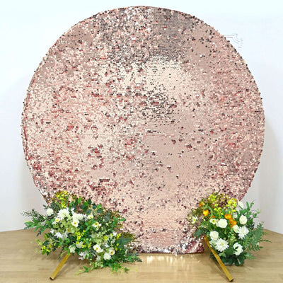 Rose gold sequin backdrop with floral arrangements on either side.
