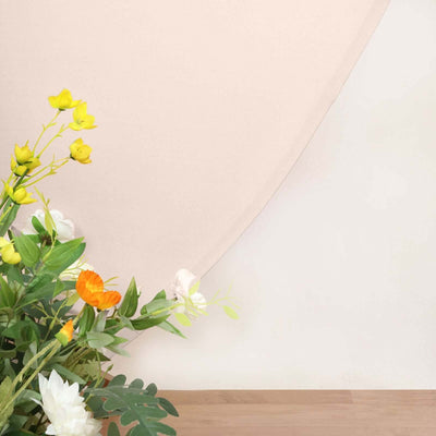 Floral arrangement with yellow and white flowers against a soft beige backdrop.