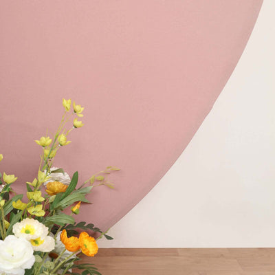 Floral arrangement with vibrant blooms and greenery against a soft pink backdrop.