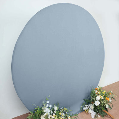 Gray round backdrop with floral arrangements at the base.