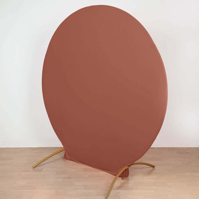Round backdrop stand with rust-colored fabric for photography setups.