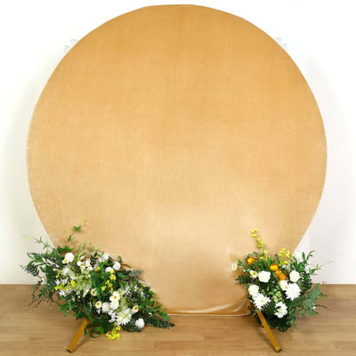 Round gold backdrop with floral arrangements on each side.