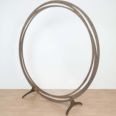 Wooden circular display stand on a light wooden floor.