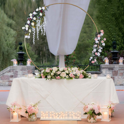 Elegant wedding reception table with floral decor and "MR & MRS" sign.