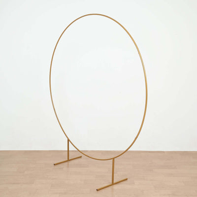 Gold circular photo backdrop stand on a plain background