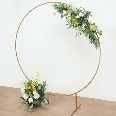 Gold circular floral arch with white and yellow flowers.