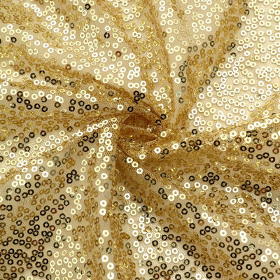 Shiny gold and black sequin fabric in a swirling pattern.