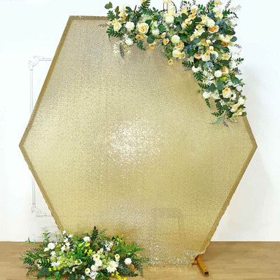 Hexagon-shaped gold backdrop with floral arrangement for photography.