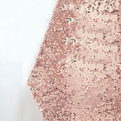 Rose gold sequin fabric draped elegantly on a plain backdrop.