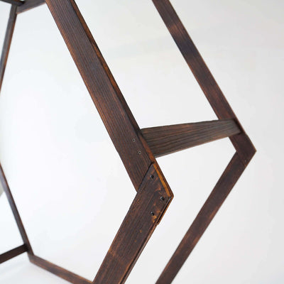 Wooden geometric frame with dark finish, showcasing intricate joinery details.