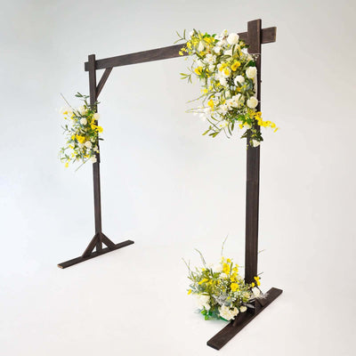 Wooden wedding arch adorned with yellow and white flowers