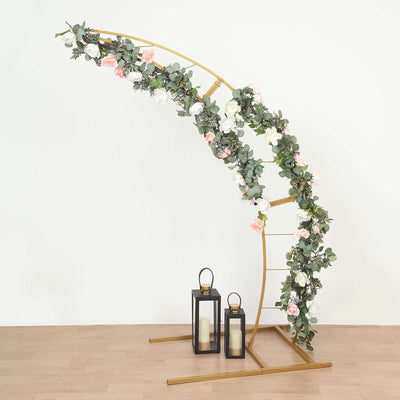 Gold flower arch with greenery and lanterns for events or weddings.