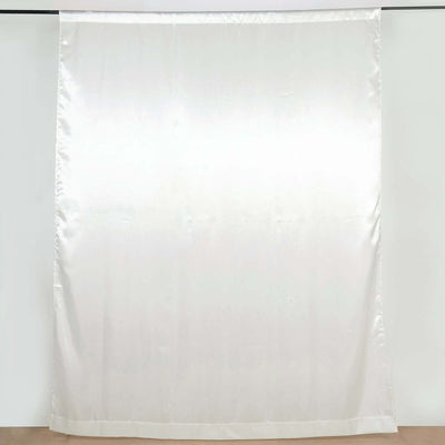 White satin curtain panel on a plain backdrop.