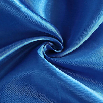 Shiny blue fabric texture in a swirling pattern.