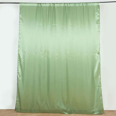 Green satin curtain hanging against a plain backdrop.