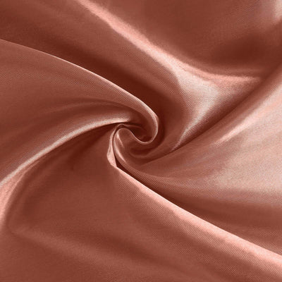 Satin fabric in soft peach color with a smooth texture.
