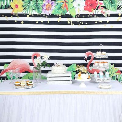 Colorful dessert table with cakes, cupcakes, and floral decorations for a celebration.