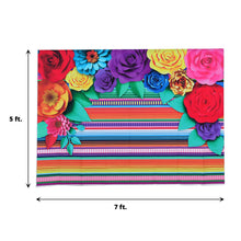 A colorful Mexican Vinyl backdrop with paper flowers on it