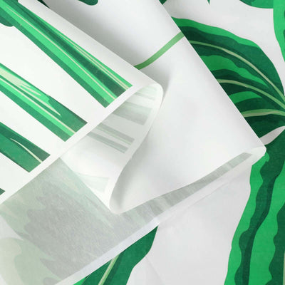Close-up of green leaf-patterned fabric with a white background.
