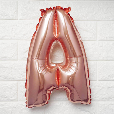 Rose gold letter A balloon on a white background.