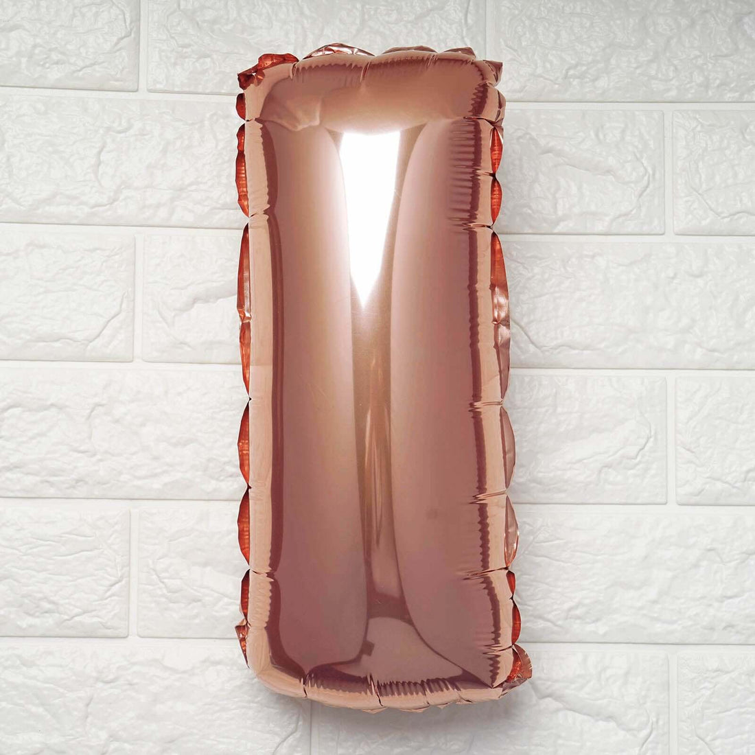 Rose gold balloon number one on a white background.