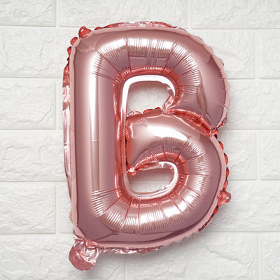 Rose gold foil letter B balloon on a white background.