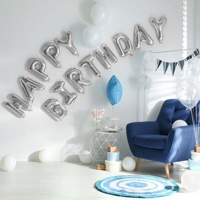 Blue chair with "HAPPY BIRTHDAY" balloons and decor in a festive setting.