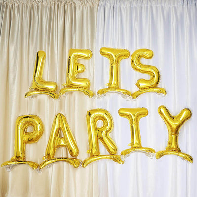 Gold "LET'S PARTY" balloons against a backdrop of draped curtains.