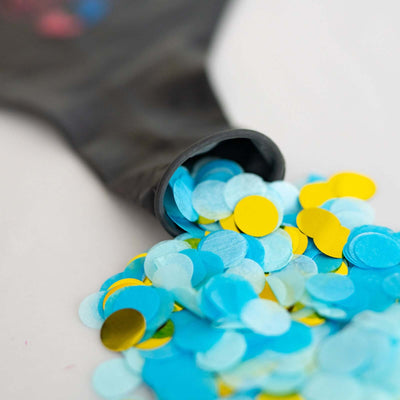 Colorful confetti spilling from a black party bag