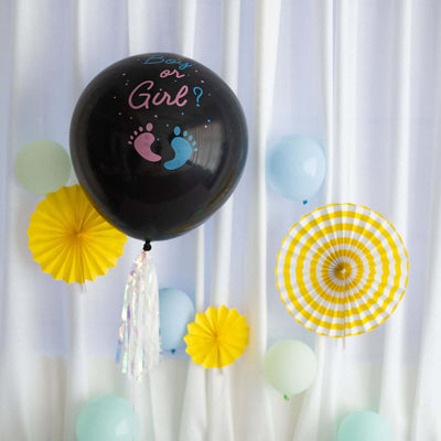 Black balloon with "Boy or Girl?" text and decorative paper fans and balloons.