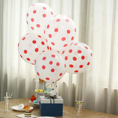 Red polka dot balloons arranged in a centerpiece on a table.