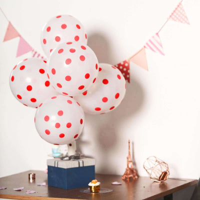 Colorful polka dot balloons with a festive backdrop on a table.