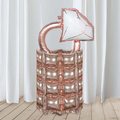 Rose gold diamond-shaped balloon decoration on a pedestal.
