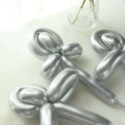 Silver balloon decorations shaped like bows on a light background.