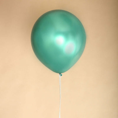 Teal balloon with a string on a soft beige background.