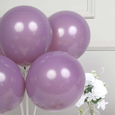 Purple balloons with a reflective surface and a floral arrangement in the background.