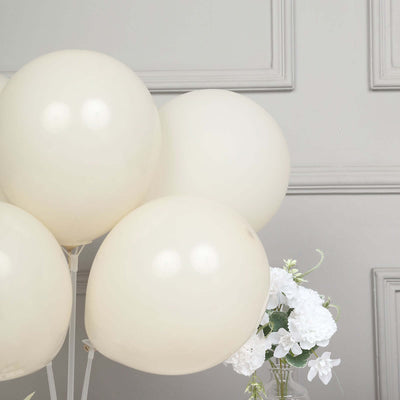 Cream balloons arranged with white flowers in a decorative setup.