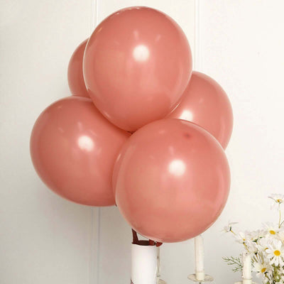 Pink balloons clustered together on a plain backdrop.