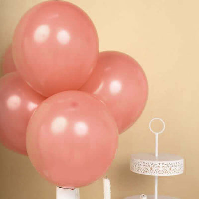 Pink balloons clustered together with a white cake stand in the background.