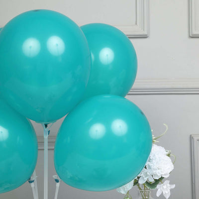 Turquoise balloons arranged with flowers in a decorative setting.