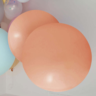 Two large peach balloons floating against a light background.