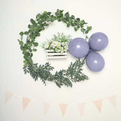 Floral arrangement in a wooden crate with purple balloons and greenery decor.