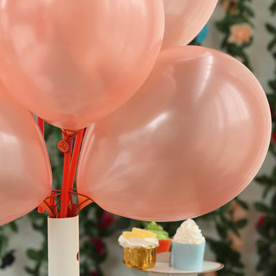 Pink balloons tied to a white holder, set against a floral backdrop.